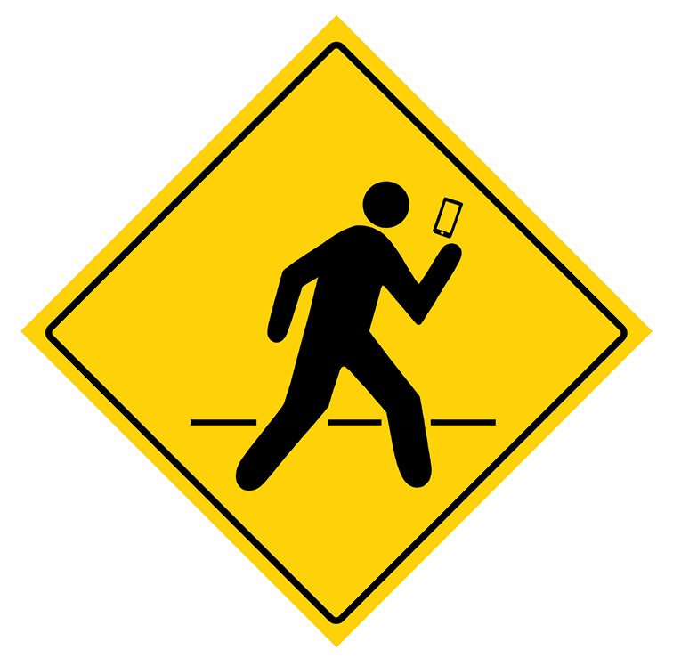 A road sign warning drivers of inattentive pedestrians crossing the road while on their smartphones